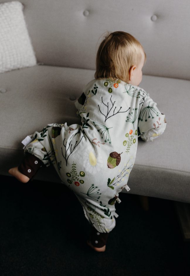 Baby wearing Fluffy Ducks Sleep Suit in a cozy setting